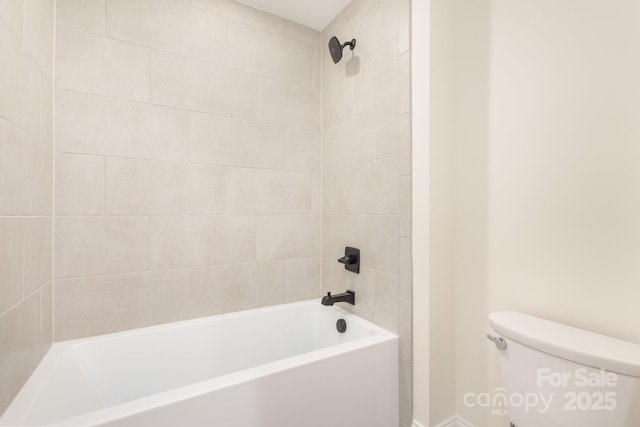 bathroom with toilet and tiled shower / bath combo