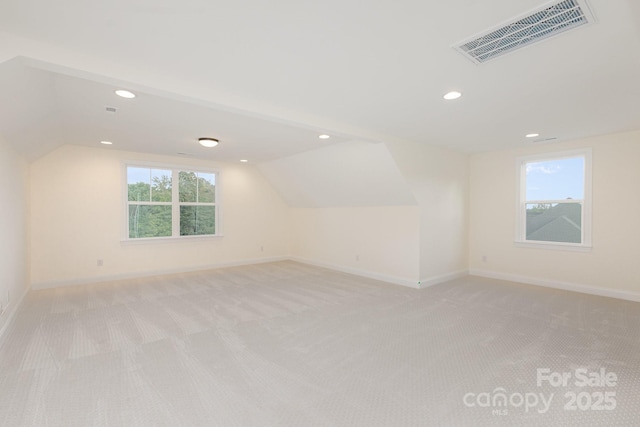 additional living space with vaulted ceiling and light colored carpet