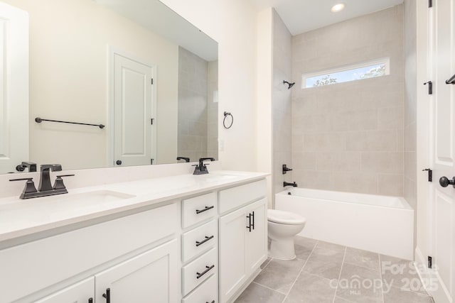 full bathroom with tiled shower / bath combo, vanity, tile patterned floors, and toilet