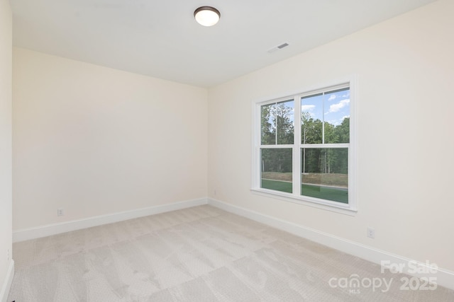 empty room with light carpet, visible vents, and baseboards