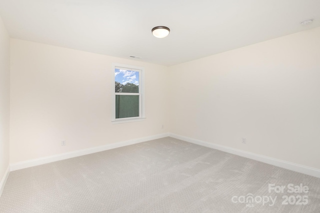 empty room with baseboards and light carpet