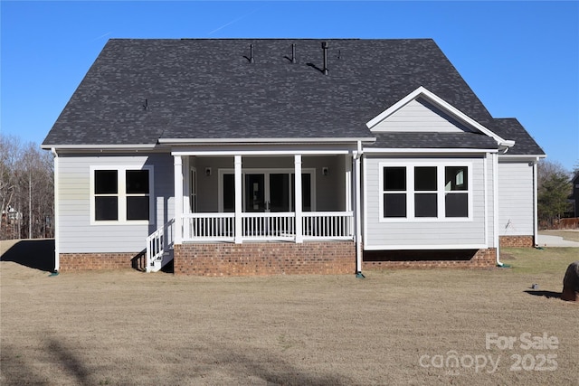 rear view of house with a porch and roof with shingles