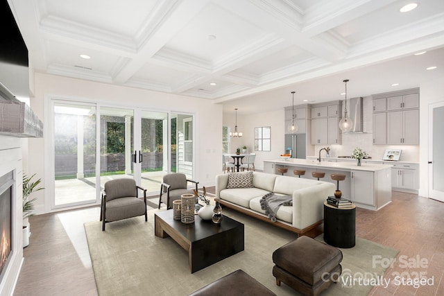 living room with beamed ceiling, light wood-style flooring, a warm lit fireplace, french doors, and coffered ceiling