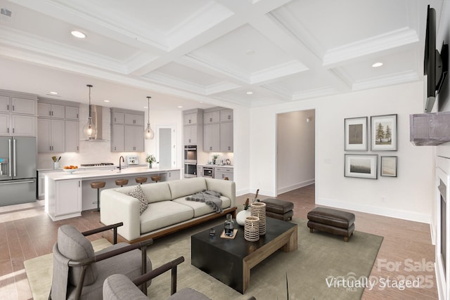 living area featuring beam ceiling, coffered ceiling, and light wood finished floors