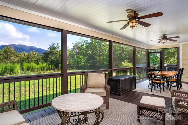 sunroom / solarium featuring ceiling fan and a mountain view