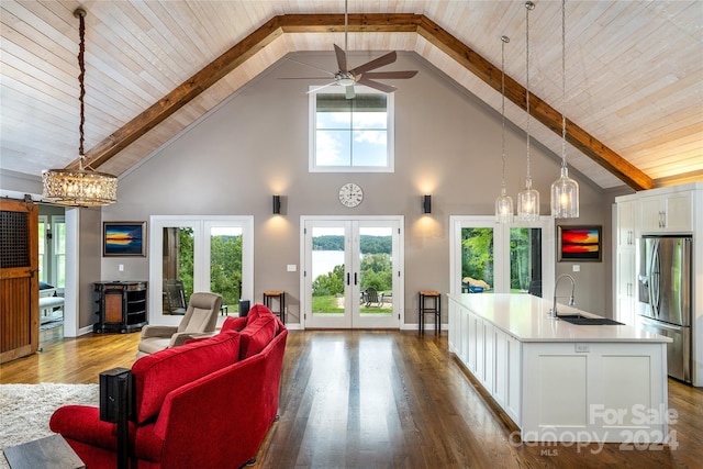 interior space with hardwood / wood-style floors, ceiling fan with notable chandelier, high vaulted ceiling, and french doors