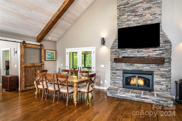 dining room with high vaulted ceiling, dark hardwood / wood-style floors, a stone fireplace, beam ceiling, and a barn door