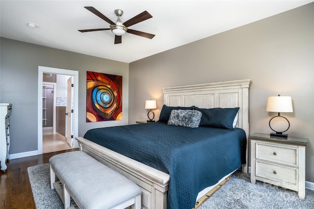 bedroom featuring ceiling fan, hardwood / wood-style floors, and connected bathroom