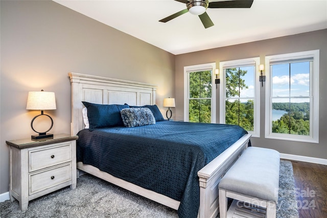 bedroom with dark hardwood / wood-style flooring and ceiling fan