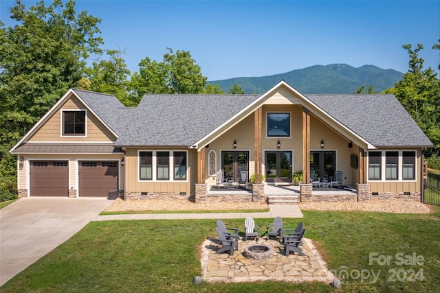 view of front of property featuring a front yard, a patio, a fire pit, and a mountain view