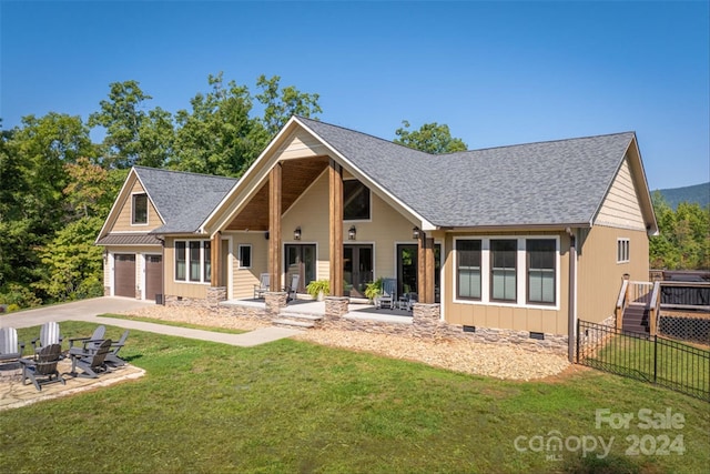 exterior space featuring a garage, a deck, and a lawn