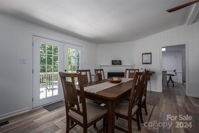 dining room with french doors, dark hardwood / wood-style floors, vaulted ceiling, and wooden walls