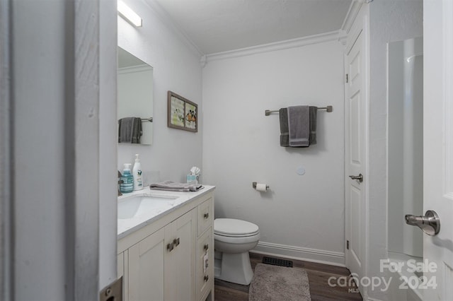 bathroom with vanity, hardwood / wood-style flooring, toilet, and crown molding