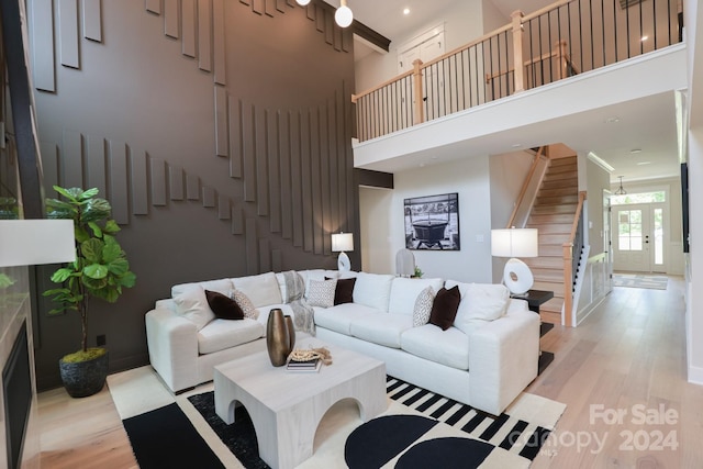 living room with light hardwood / wood-style flooring and a high ceiling