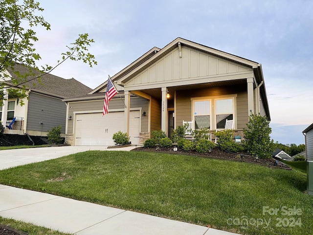 view of front facade with a front yard, a garage, and covered porch