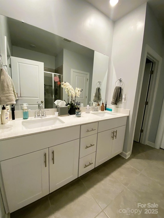 bathroom featuring tile patterned floors, an enclosed shower, and vanity