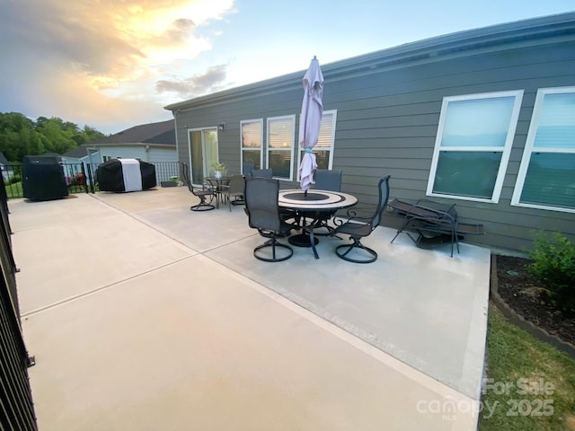 patio terrace at dusk with area for grilling and an outdoor fire pit