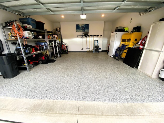 garage featuring freestanding refrigerator and a garage door opener