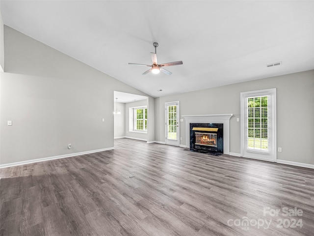 unfurnished living room with ceiling fan, lofted ceiling, a high end fireplace, and wood-type flooring