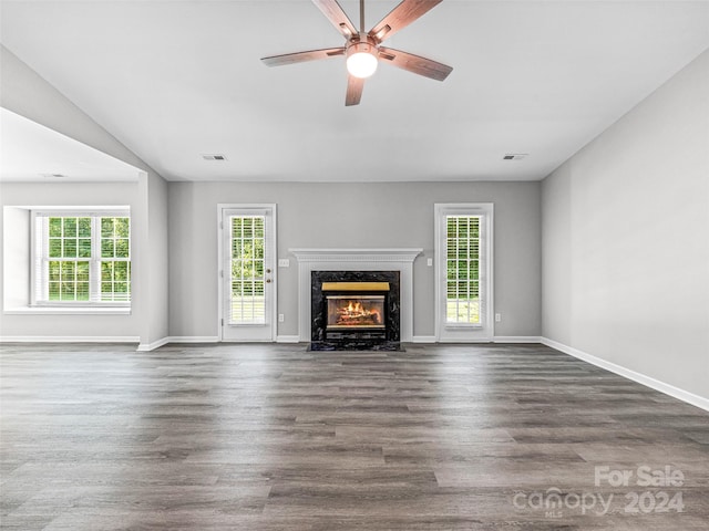 unfurnished living room featuring a wealth of natural light, hardwood / wood-style flooring, and a high end fireplace