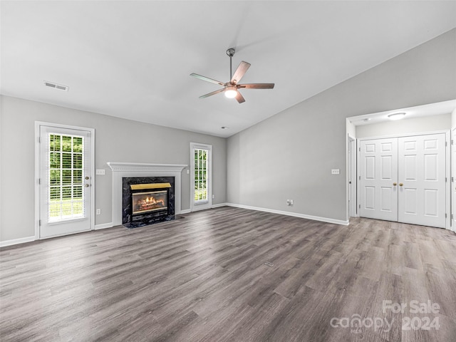 unfurnished living room featuring a fireplace, ceiling fan, vaulted ceiling, and wood-type flooring