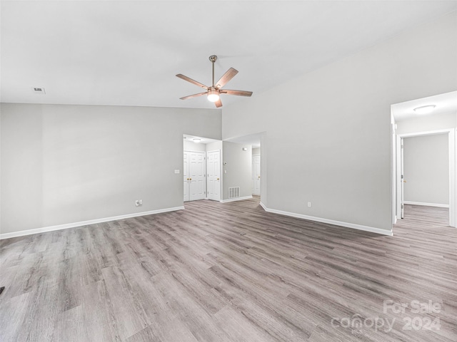 spare room featuring ceiling fan, high vaulted ceiling, and wood-type flooring