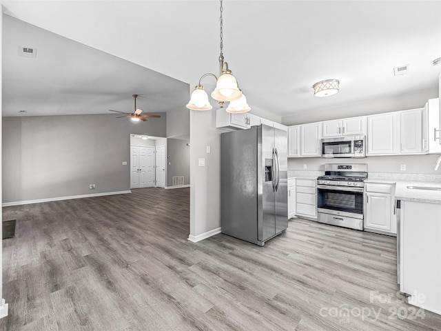 kitchen featuring appliances with stainless steel finishes, lofted ceiling, pendant lighting, and light wood-type flooring