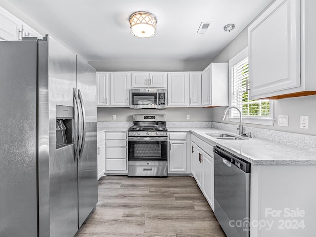 kitchen featuring sink, white cabinetry, light hardwood / wood-style flooring, and appliances with stainless steel finishes