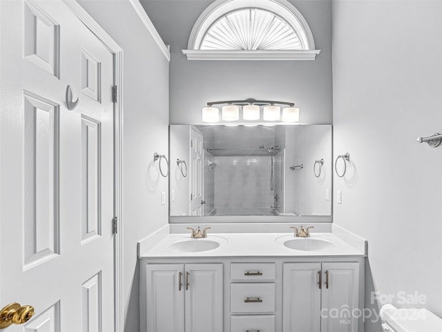 bathroom with crown molding, toilet, a tile shower, and vanity