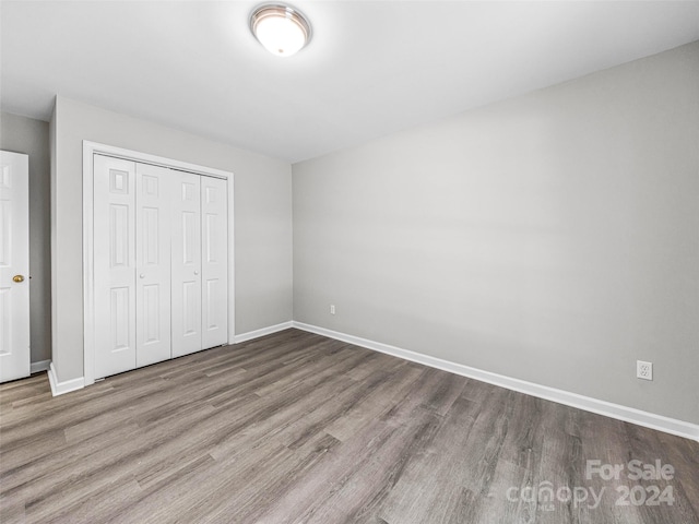 unfurnished bedroom with hardwood / wood-style floors and a closet