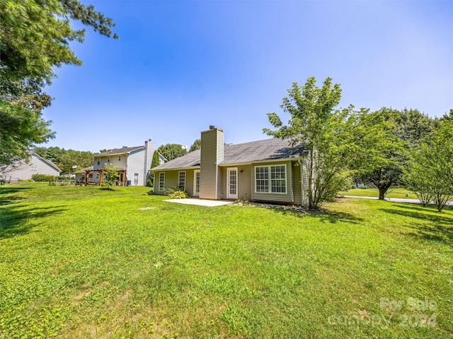 back of house featuring a lawn