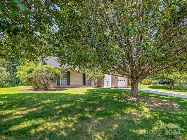 view of property hidden behind natural elements featuring a front yard