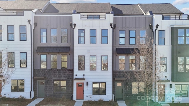 multi unit property featuring a standing seam roof and roof with shingles