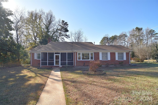 ranch-style house featuring a sunroom and a front lawn