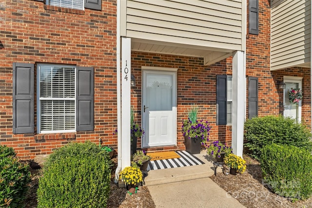 entrance to property featuring brick siding