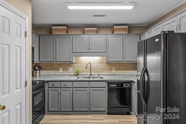 kitchen featuring black appliances, a sink, visible vents, and gray cabinetry