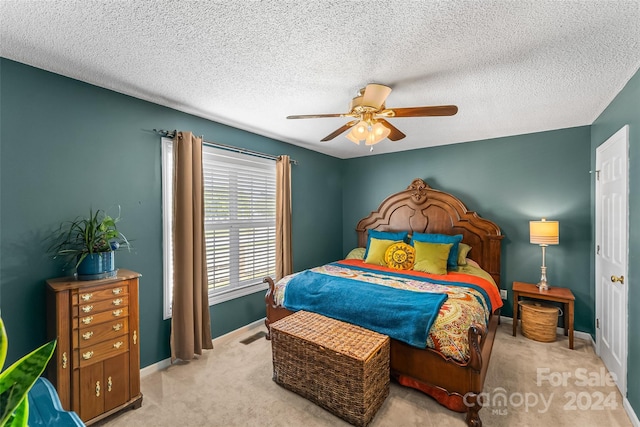 bedroom with carpet floors, a textured ceiling, baseboards, and a ceiling fan