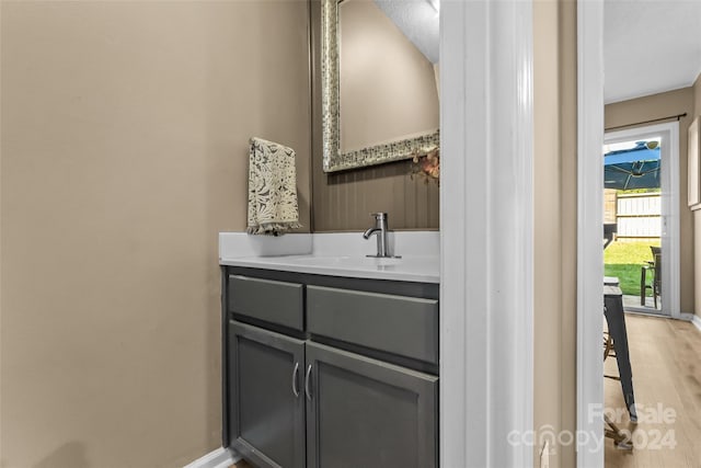 bathroom featuring baseboards, wood finished floors, and vanity