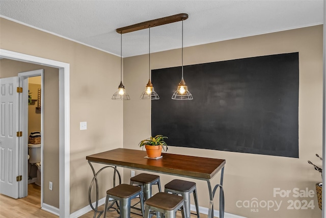 dining space featuring wood finished floors and baseboards