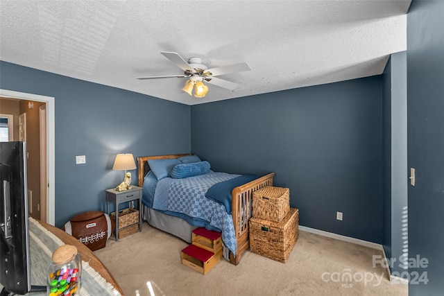 carpeted bedroom with a ceiling fan, a textured ceiling, and baseboards