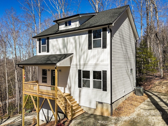 view of front of property featuring stairway, roof with shingles, a deck, and central air condition unit