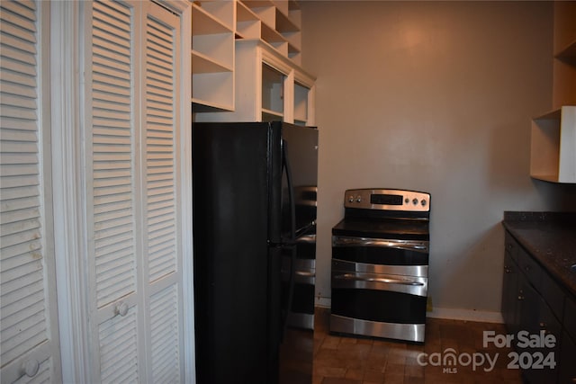 kitchen featuring dark tile patterned floors, electric range, and black fridge