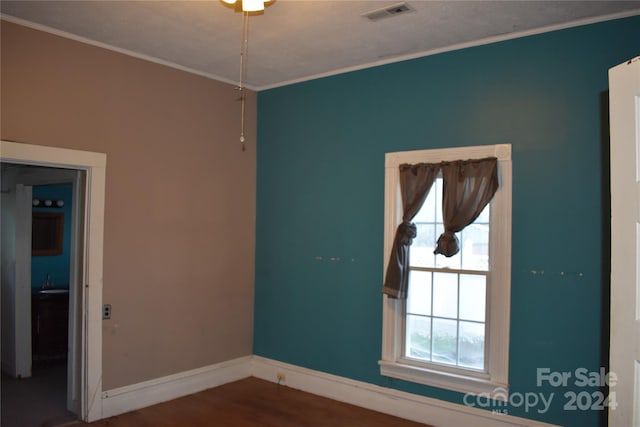 unfurnished room featuring crown molding and hardwood / wood-style floors