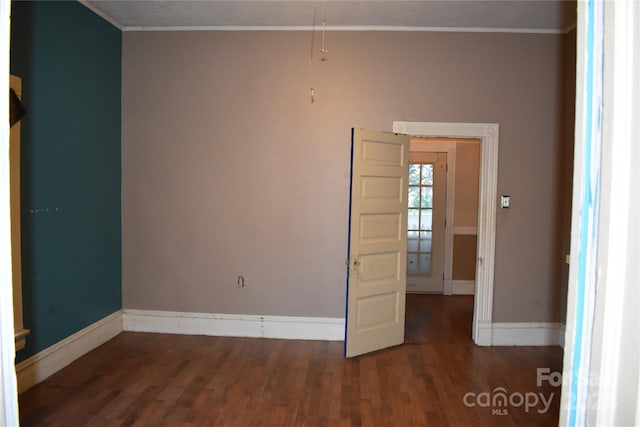 empty room featuring ornamental molding and wood-type flooring