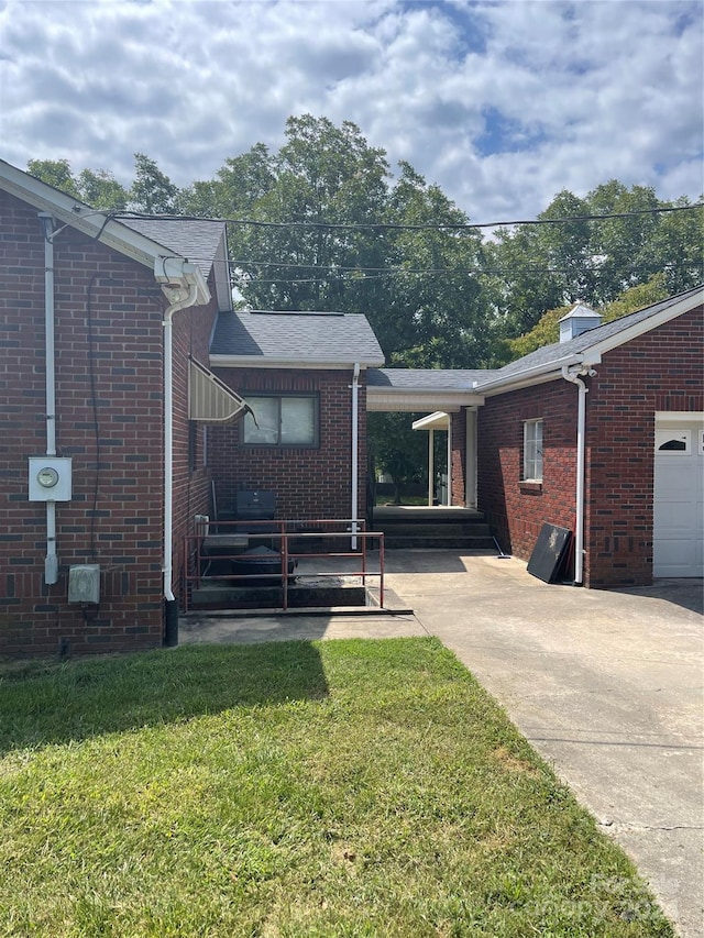 back of property featuring a yard and a garage