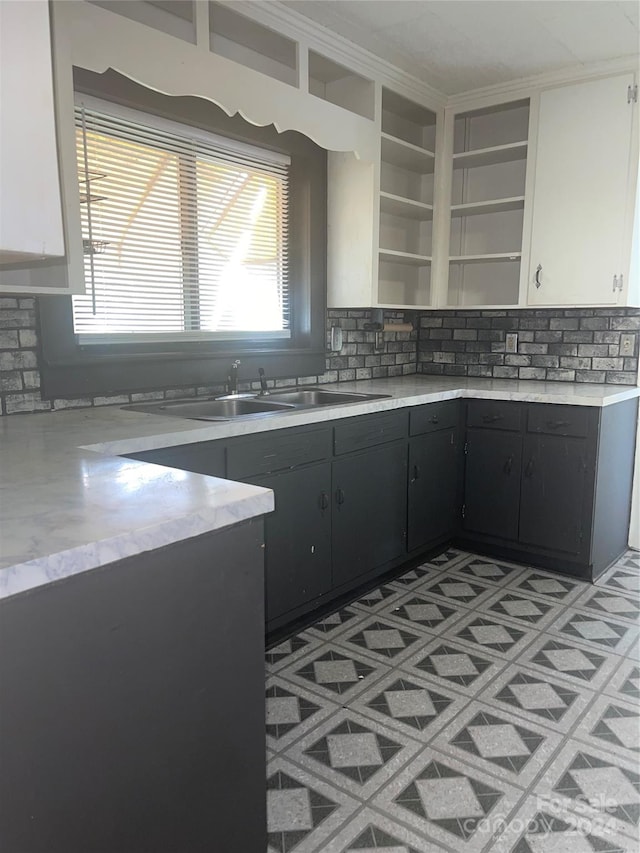 kitchen with white cabinets, tasteful backsplash, and sink