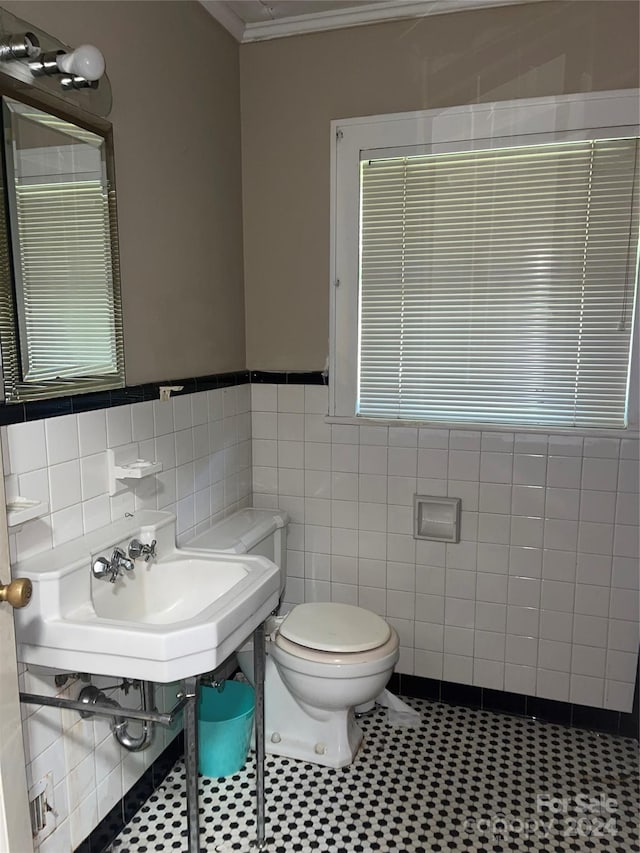 bathroom featuring sink, toilet, tile patterned floors, tile walls, and crown molding