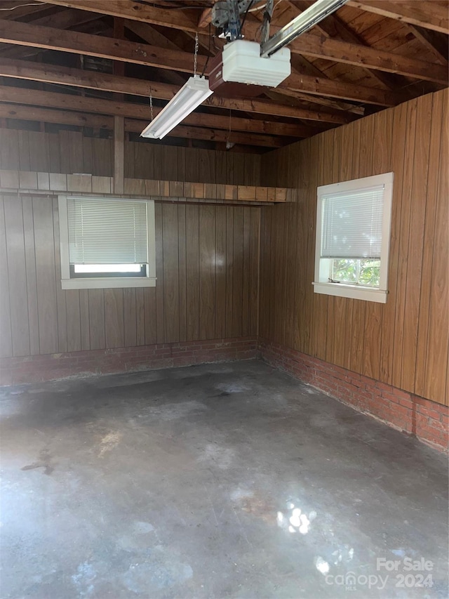 garage featuring a garage door opener and wood walls