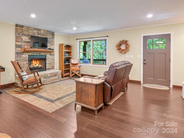 living room featuring a fireplace, ornamental molding, and hardwood / wood-style floors