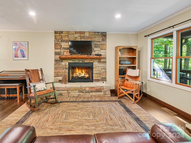 living room with ornamental molding, hardwood / wood-style floors, and a fireplace